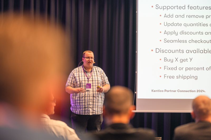 Photo of Liam Goldfinch presenting at Kentico Connection 2024, speaking to an engaged audience.