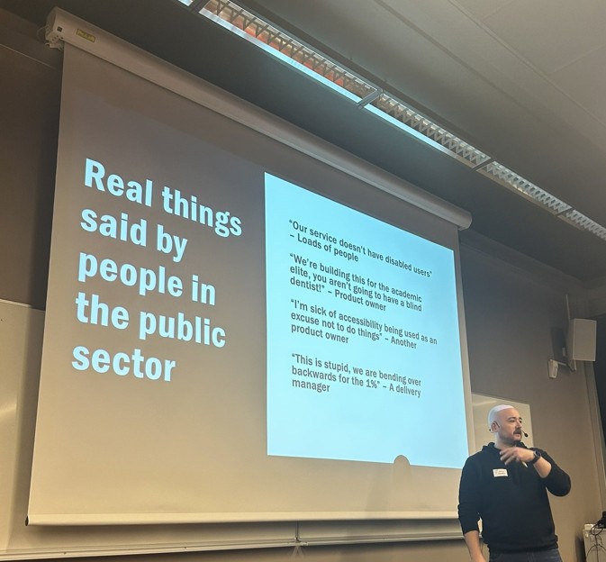 Image shows a slide being presented by Shaun Conner, titled "Real things said by people in the public sector" and with the quotes "Our service doesn't have disabled users" -  loads of people. "We're building this for the academic elite, you aren't going to have a blind dentist" - Product owner.  "I 'm sick of accessibility being used as an excuse not to do things" - Another product owner. "This is stupid we are bending over backwards for the 1%" a delivery manager